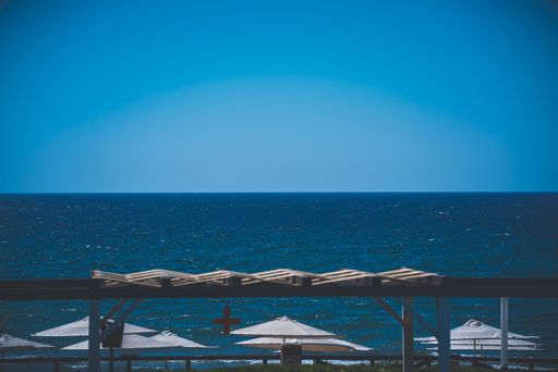 A beautiful shot of white umbrellas on a beach with a background of seascape