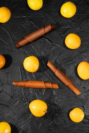 Pastila fruit skin rolls with fruits on a black background. Vegetarian food. Sweet without sugar.