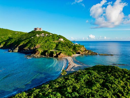 A gorgeous aerial view of green hills on Saint Thomas overlooking the bright blue waters of the Caribbean
