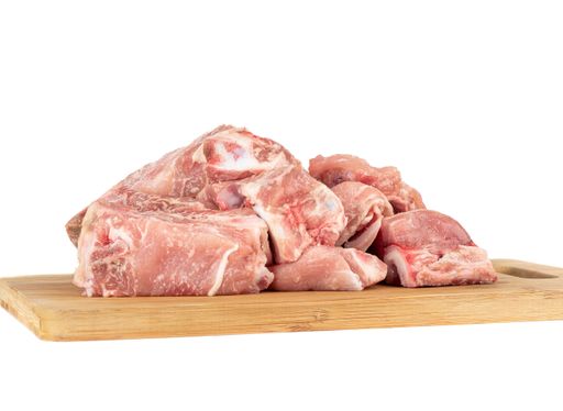 Pieces of Pork meat on a wooden cutting board isolated on white background. Copy space