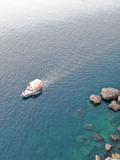 A beautiful view of a ship on a rocky shore during sunrise