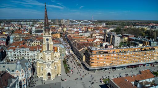 An aerial view of Novi Sad city with a catholic cathedral and dense  buildings under the blue sky, Serbia