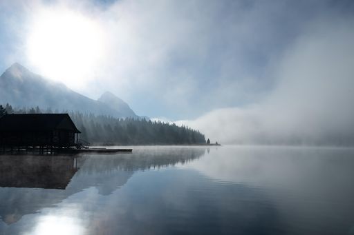 A beautiful shot of a lake coast in the daytime during misty weather