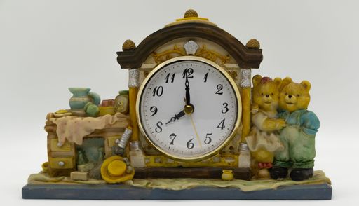 A table clock in an antique style with molded animation around on a ceramics wood