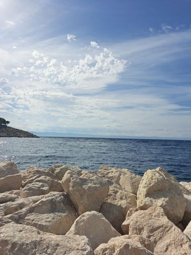 A white rocky coast with a blue sea under the sky during daytime, Adriatic Sea in Croatia