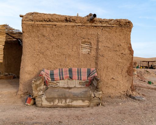 An old couch in front of a building inside the desert in Marrakech, Morocco
