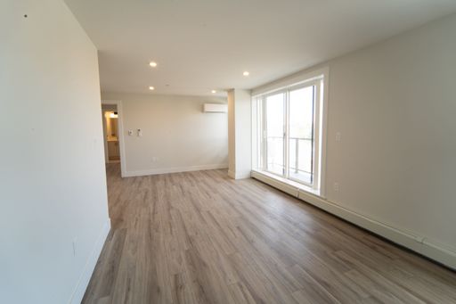 A closeup shot inside an empty living room of a house with white walls and wide windows