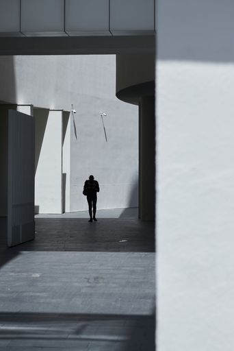 A vertical shot of a black silhouette of a person in black and white taken in Bilbao, Spain