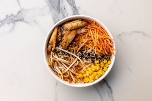 A top view of a delicious poke bowl with meat and corn served on the marble table