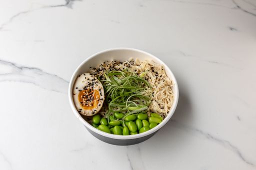 A  tasty noodle soup bowl with green beans and an egg on the marble table