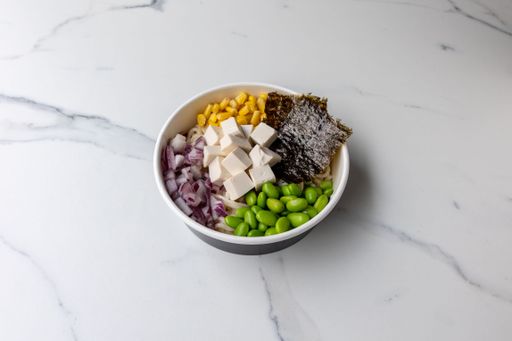 A tasty poke bowl with tofu cheese on the marble table
