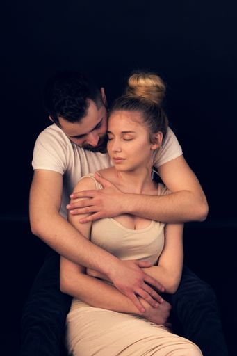 A portrait of a white Caucasian couple posing on a dark background
