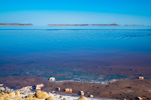 A scenic view of rocky shore of Lake Urmia in Iran under a cloudless blue sky on a sunny day