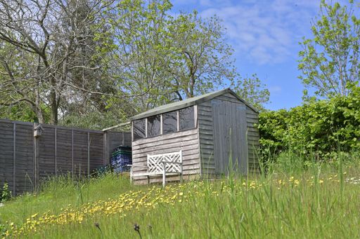 A small wooden lodge in the green grass