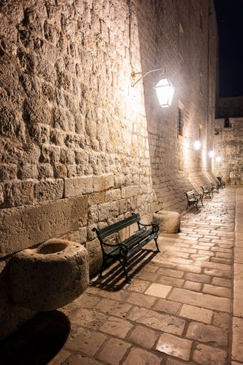 Empty benches against an old stone wall overlooking the beautiful  Adriatic Sea in Dubrovnik