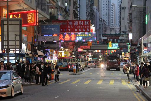 A beautiful shot of a busy crowded street with people and cars in downtown Hong Kong