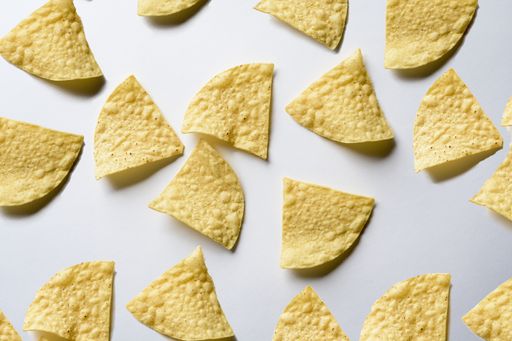 An overhead shot of nachos on a white surface - great for background