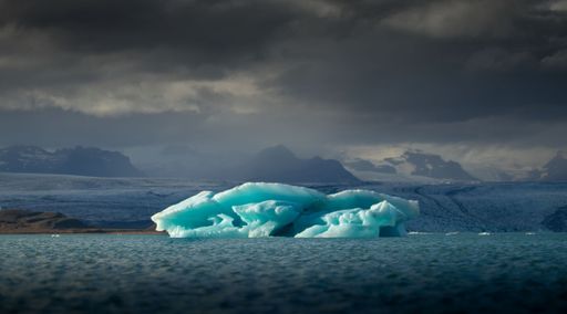 The view of a floating iceberg against the background of the cloudy sky.