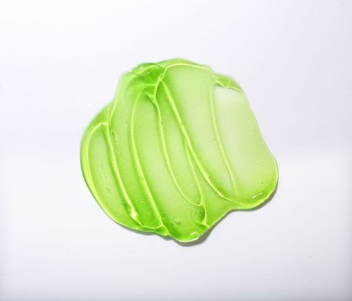 A closeup shot of a green gel texture of aloe isolated on a white background.