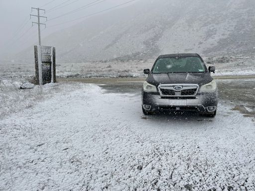 A 2013 Subaru Forester in foggy Arthur's pass covered in snow in New Zealand