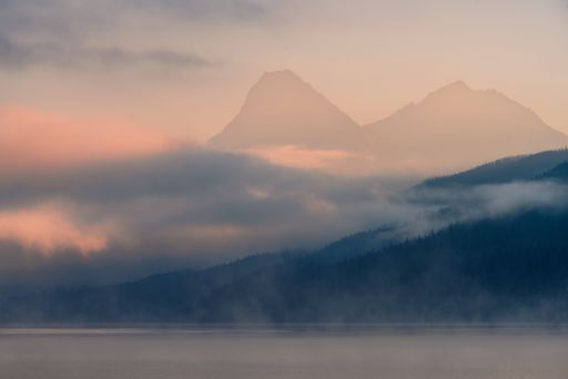 An image of the top of the mountains in the clouds during the sunset.