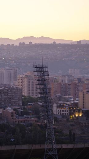 A vertical shot of old and new buildings in Yerevan, Armenia under a yellow sky at sunset