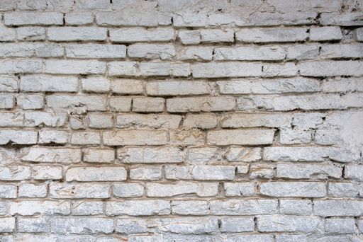 Texture of a weathered white brick wall