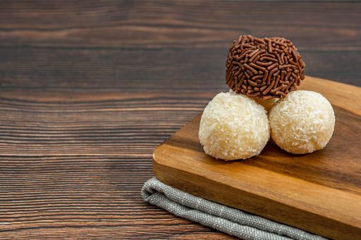A closeup of chocolate Brazilian Brigadeiro and Beiginho on a cutting board with copy space