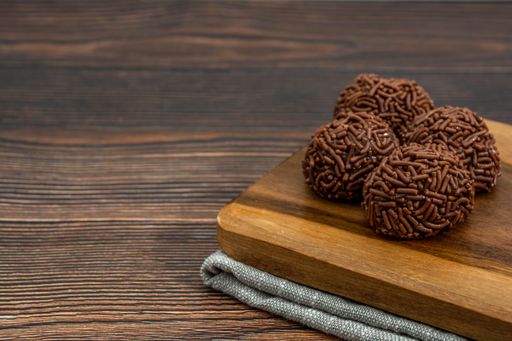A closeup of chocolate Brazilian Brigadeiro on a wooden table with copy space
