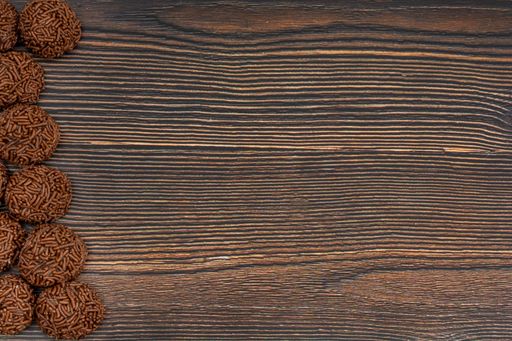 A top view of chocolate Brazilian Brigadeiro on a wooden table with copy space