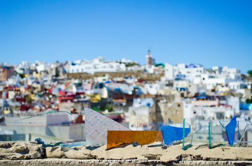 A selective focus shot of pieces of glass with a beautiful city on the background