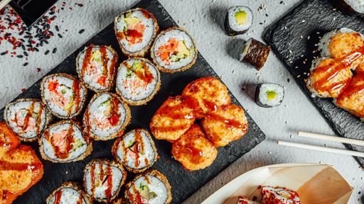 A top view of a set of delicious fresh sushi rolls served on a black board