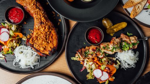 A top view of fresh delicious steak and chicken bbq served with salads and ketchup on a table