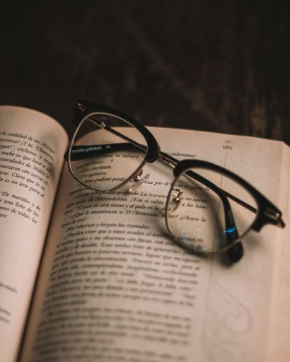 A closeup of glasses on open book