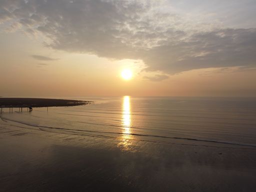 A beautiful view of the sea under the cloudy sky during orange sunset