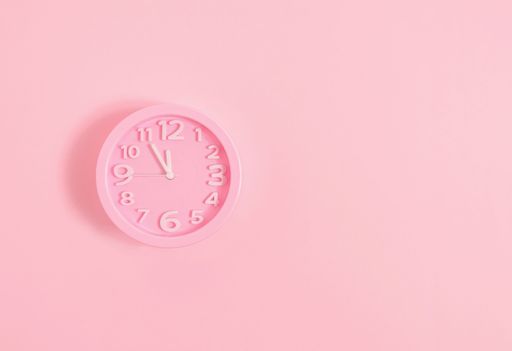 A pastel pink wall alarm clock on pink painted wall-Christmas Eve or New Year concept