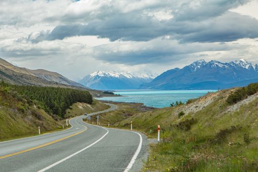 A road leading to the beautiful Pukaki Lake with the Aoraki mountain in the background on a gloomy day