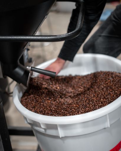A vertical shot of roasted coffee beans in a bucket