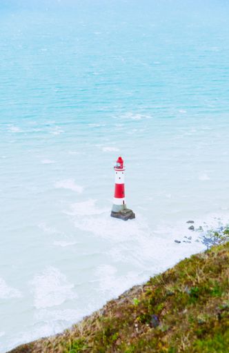 A vertical shot of a lighthouse in the open sea