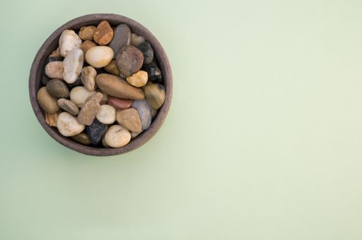 A high angle shot of a bowl filled with colorful rocks and pebbles