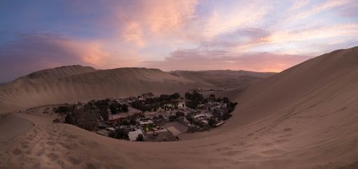 A high angle shot of Huacachina village during a wonderful sunset above the sand dunes in Ica, Peru