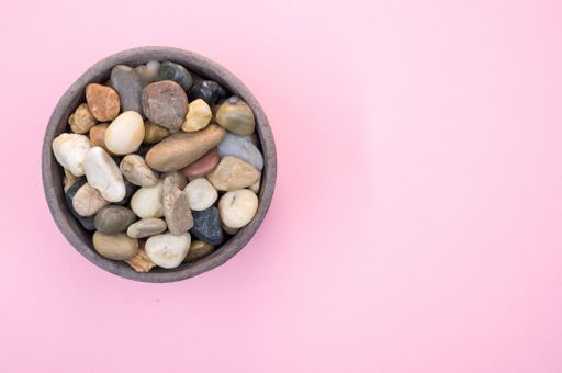 A high angle shot of a bowl filled with colorful rocks and pebbles