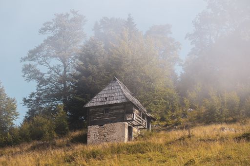 The small old hut on the hill surrounded by greens and trees
