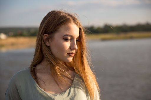 A portrait of a caucasian pretty girl looking side against seascape