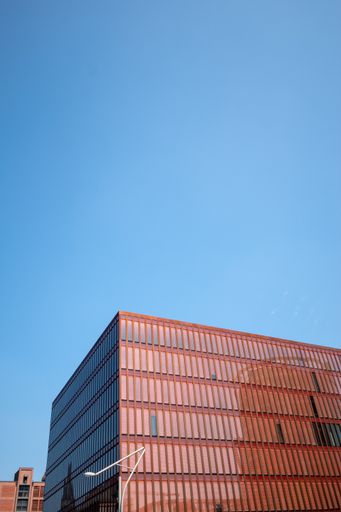 A vertical shot of a modern red building with narrow windows in Hamburg, Germany