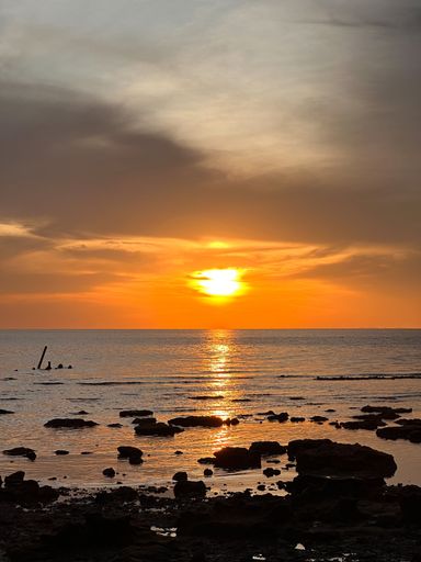 A vertical shot of the beautiful sunset over the ocean in Pulau Aur Island, Malaysia