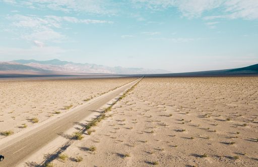A mesmerizing shot of a huge salt lake with an endless road in the Death Valley