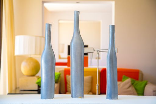 A closeup of three stylish vases on a table in a room of a luxury hotel