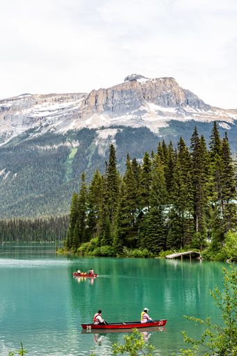 A vertical shot of the freshwater Emerald Lake and red canoes in Yoho National Park Banff Canada