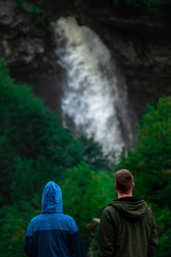 A back view of a couple watching the scenic waterfall